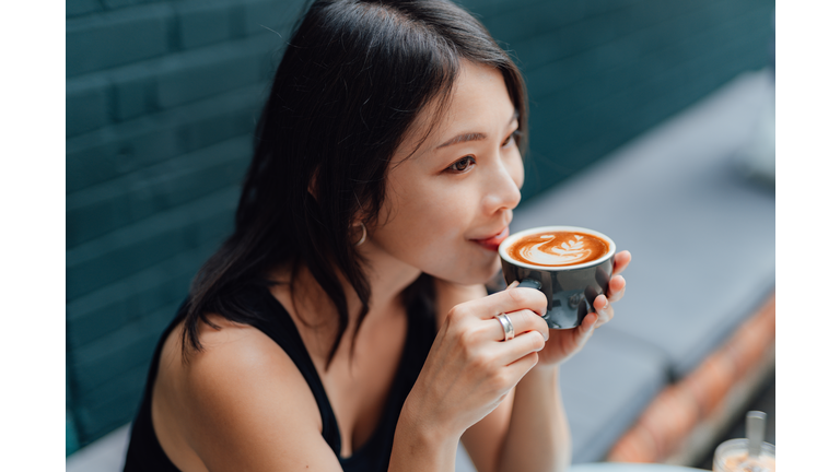 Young woman enjoying a peaceful morning with a cup of coffee in cafe
