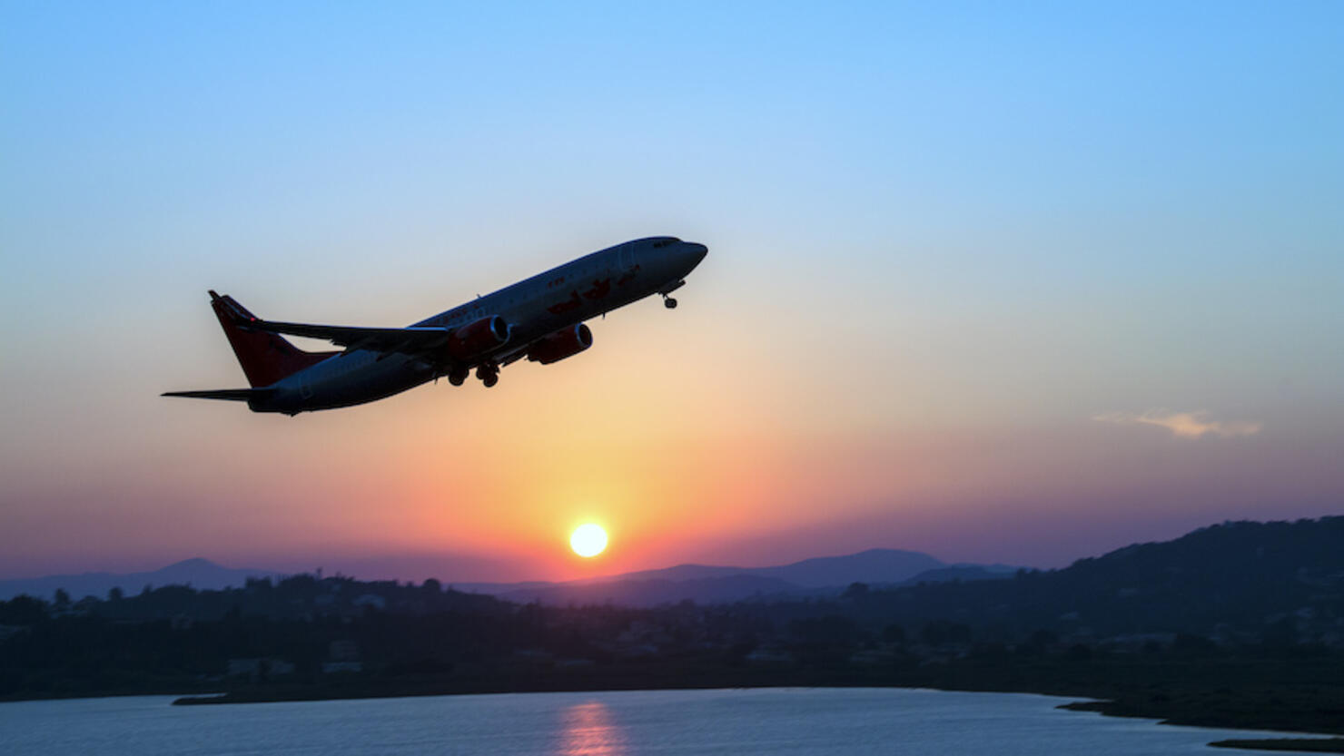 Silhouette of an airplane just after take off during sunset