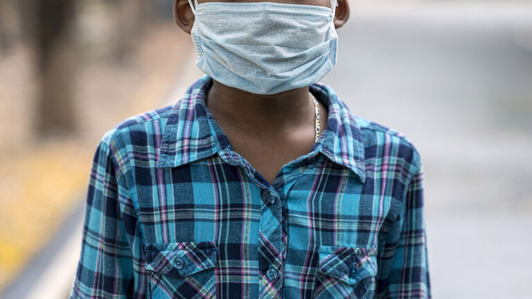 Boys wear face mask in the public park during COVID-19 pandemic. New normal living after COVID-19 pandemic.