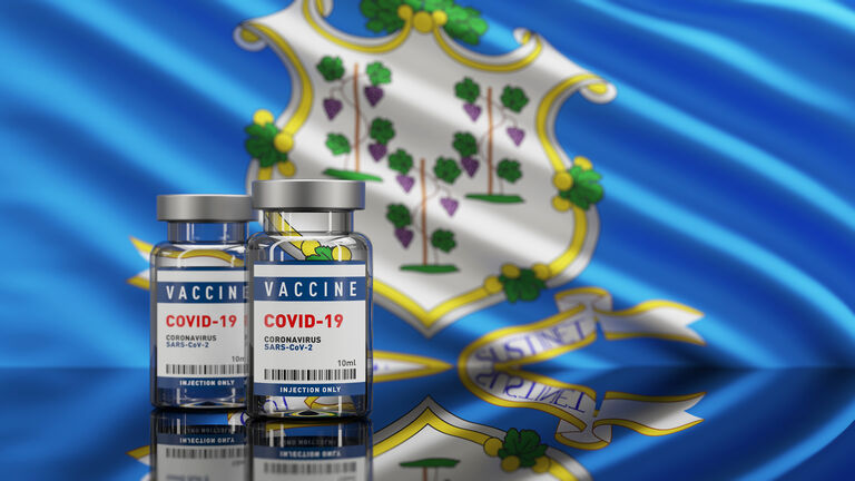 US Connecticut State Flag and Vaccine Covid-19 Corona Virus Concept bottle vial. Depth of field.