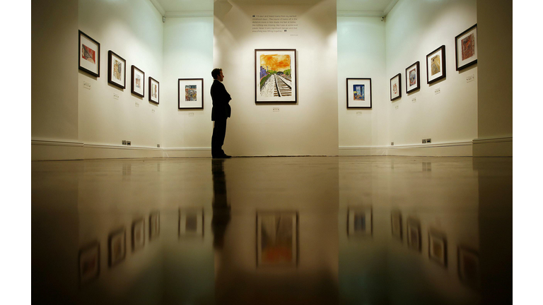 A visitor looks at a painting entitled '