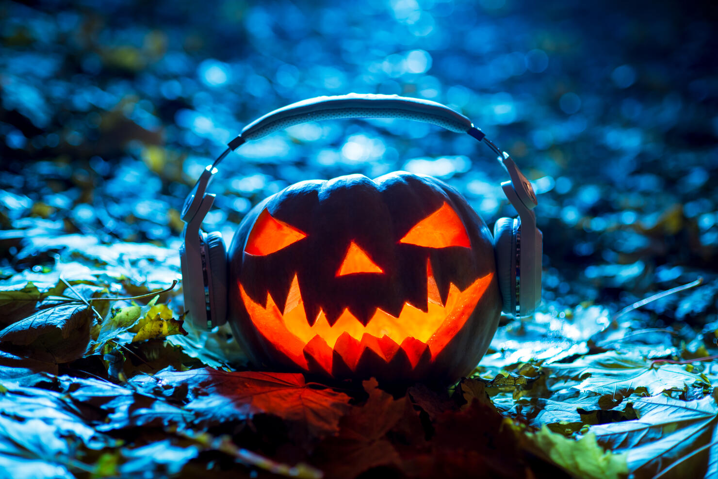 halloween pumpkin head with headphones halloween music, jack lantern on dark background