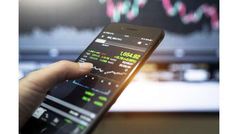 Stock market,Close up of women's hands holding smartphone