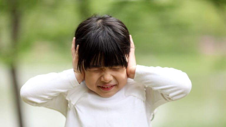Image of child playing,girl have closed her ears