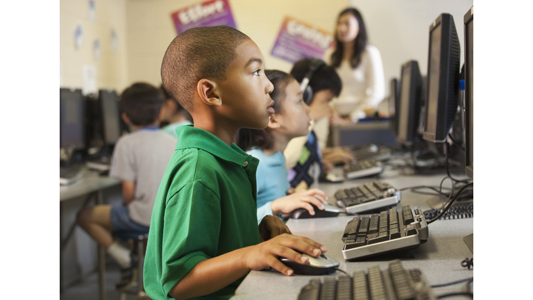 African American boy using computer in classroom