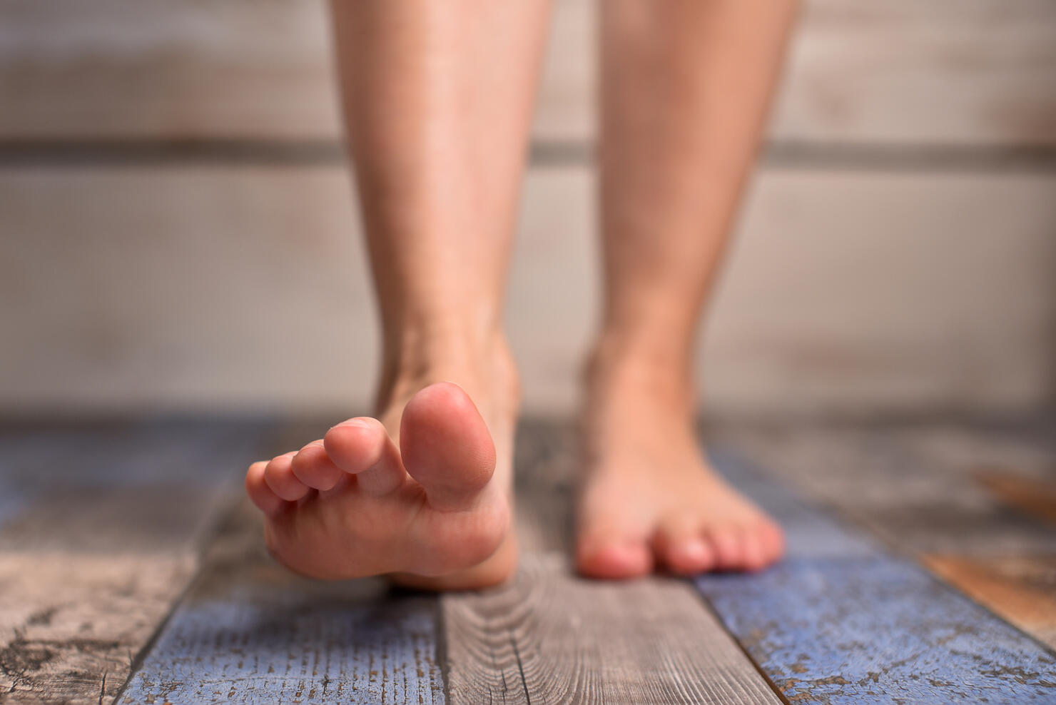 Barefoot woman with clean feet stepping on floor