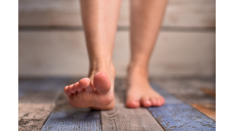 Barefoot woman with clean feet stepping on floor