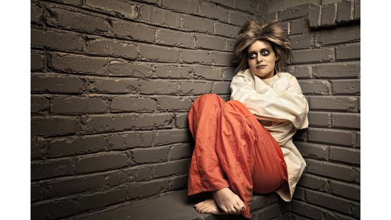 Crazy Woman wearing a straight jacket in an asylum