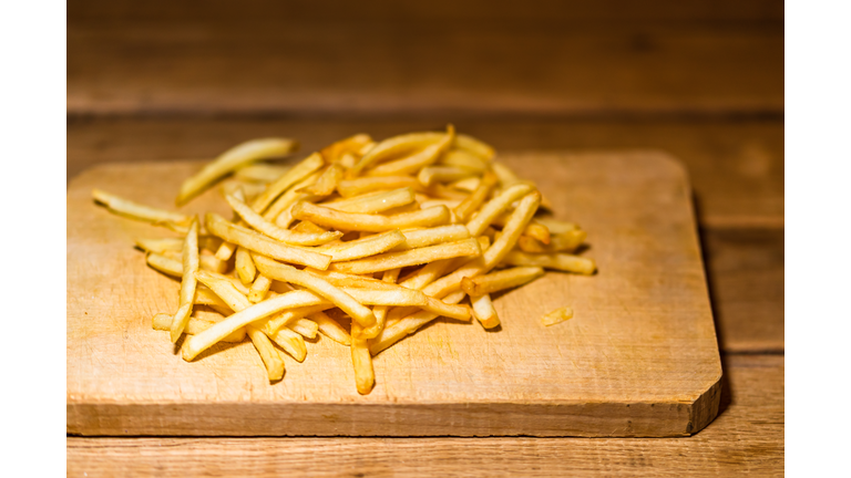 French fries on a wooden table. Food, junk food and fast food concept