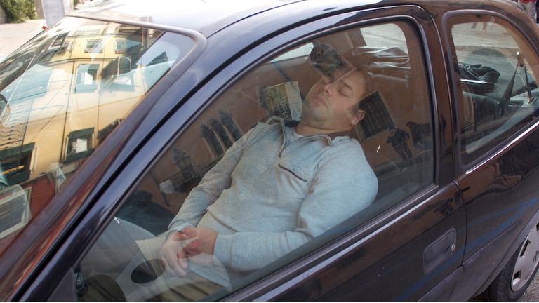 Man Sleeping In Car Seen Through Window