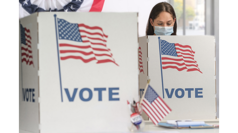 Woman in face mask voting