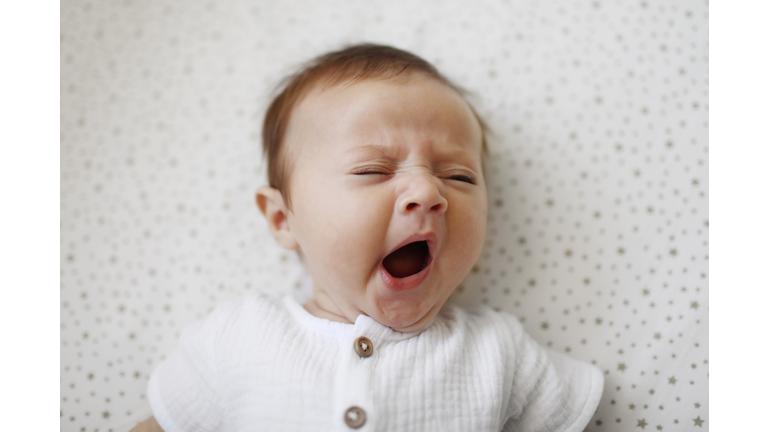 A 4 month old baby girl yawning