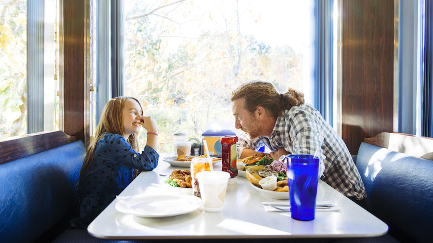 Father and daughter eating lunch in a diner