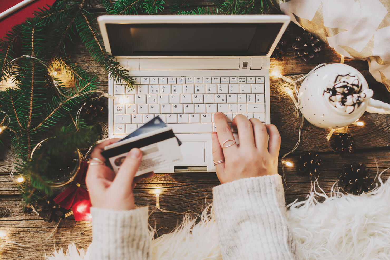 Woman using credit card to shop online, close up