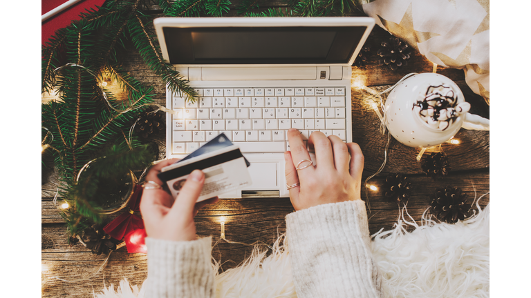 Woman using credit card to shop online, close up