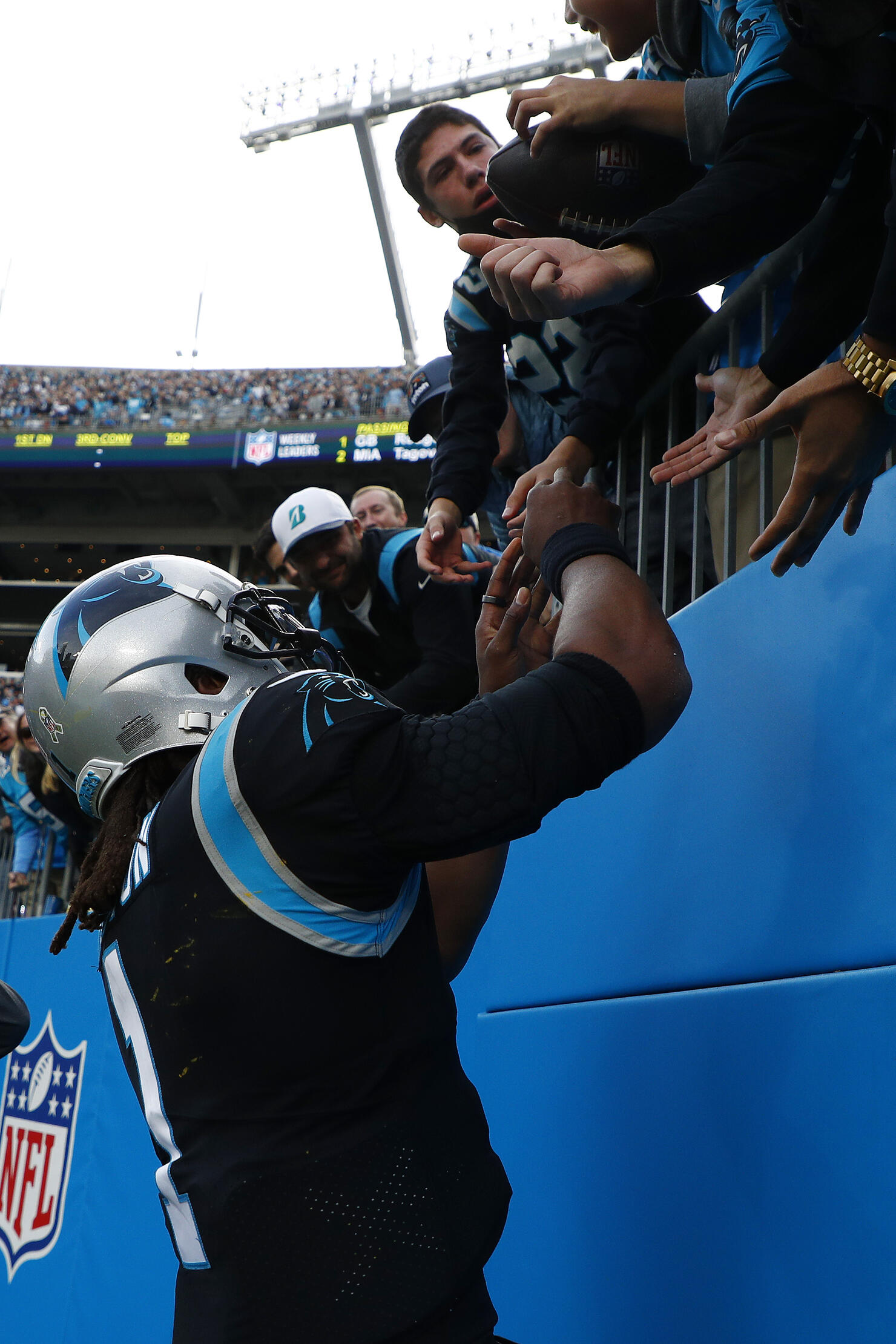 Carolina Panthers Cam Newton hands a football to a young fan after