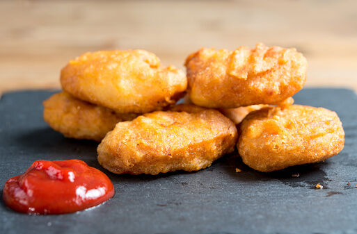 Close-Up Of Chicken Nuggets With Sauce On Granite Plate