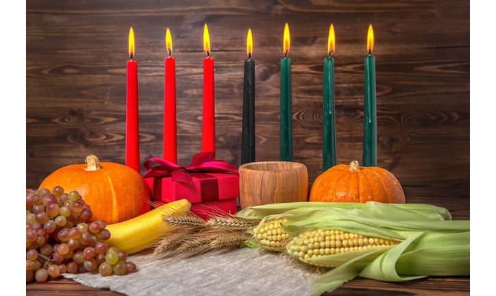 Kwanzaa festival concept with seven candles red, black and green, gift box, pumpkins, ears of wheat, grapes, corns, banana, bowl and fruits on wooden background, close up