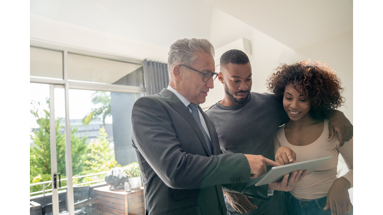 Real estate agent showing a property to an African American couple