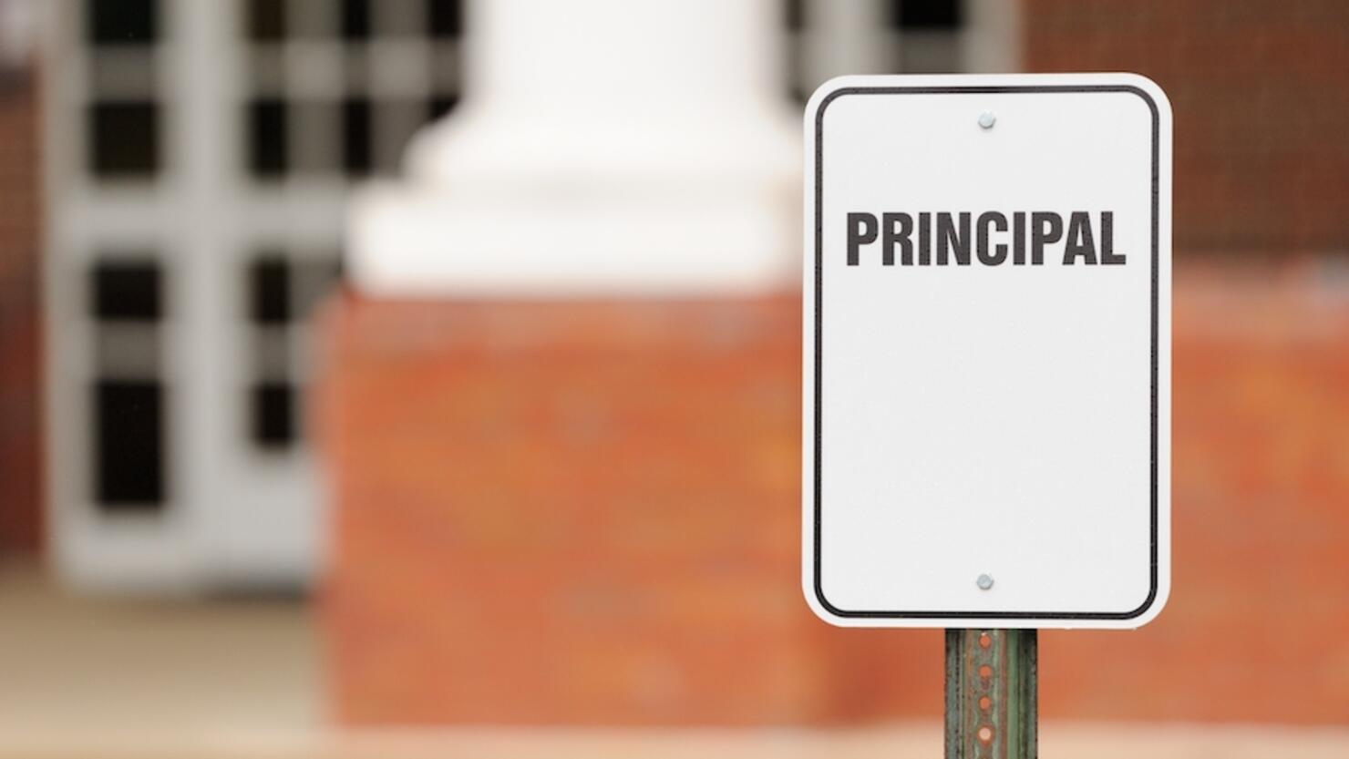 Principal sign for parking in front of school building