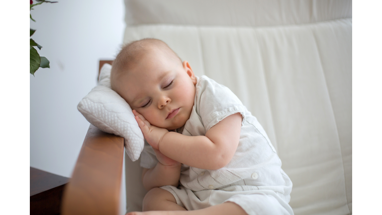 Little cute baby boy, sleeping in armchair with little pillow, cozy toddler