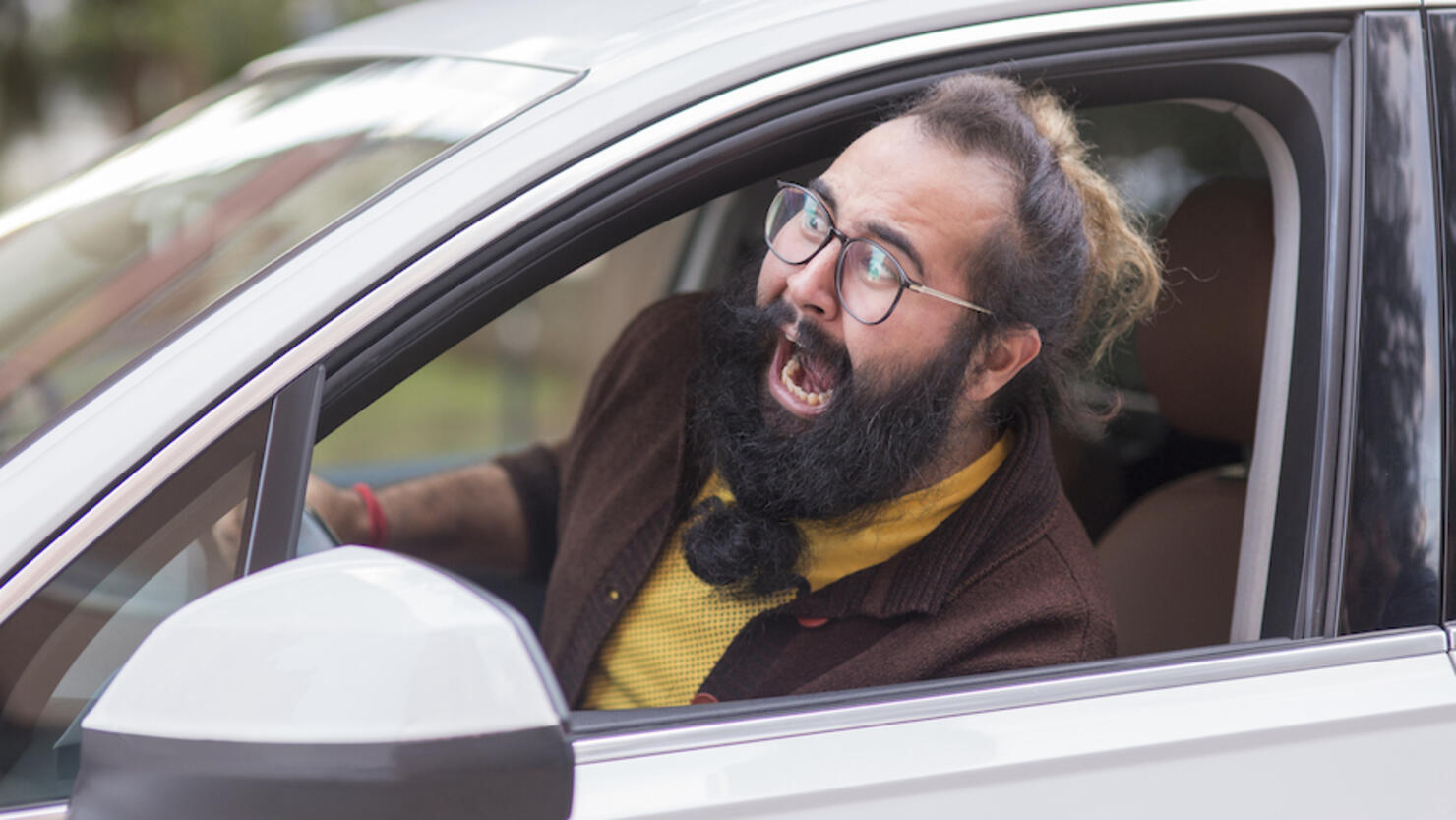 Angry man behind the wheel demonstrating road rage