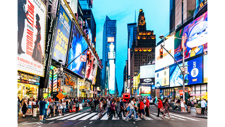 Crowds of people walking at Times Square at night, New York, USA