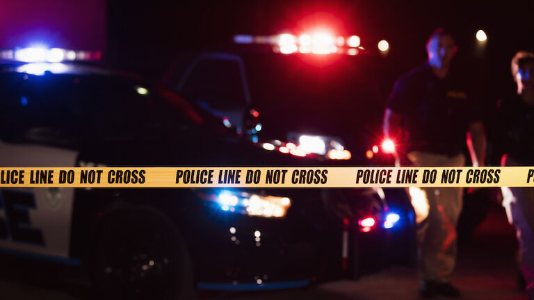 Two police officers behind crime scene tape