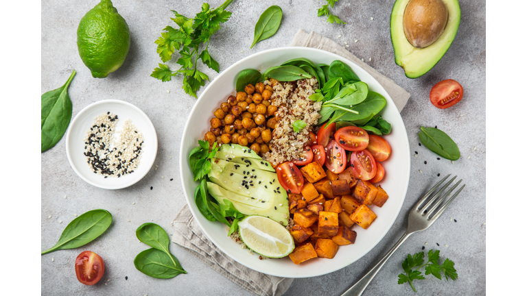 healhty vegan lunch bowl. Avocado, quinoa, sweet potato, tomato, spinach and chickpeas vegetables salad