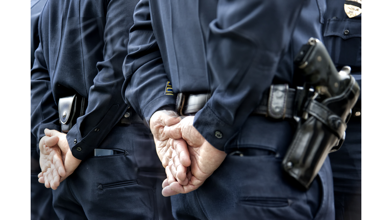 Officers standing with hands behind