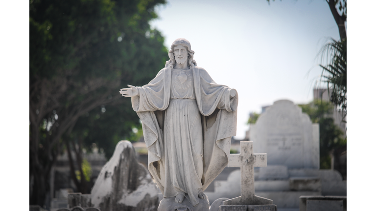Image of the sacred heart of Jesus above a grave in the cemetery.