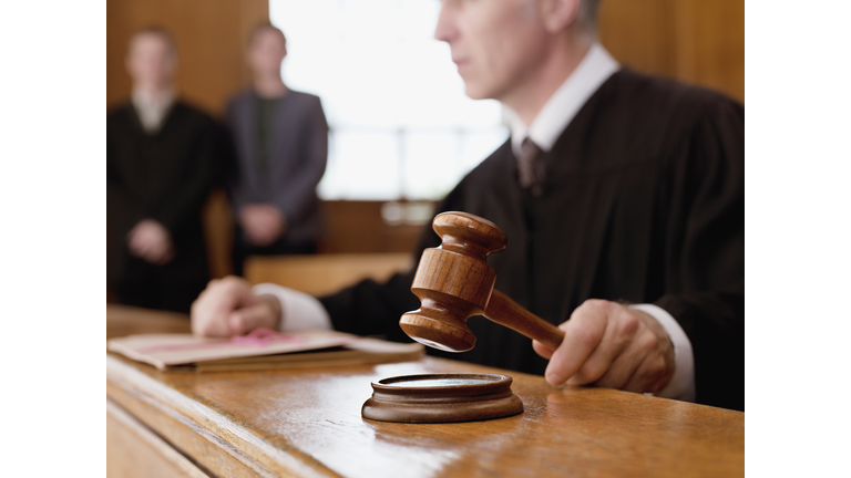 Judge holding gavel in courtroom