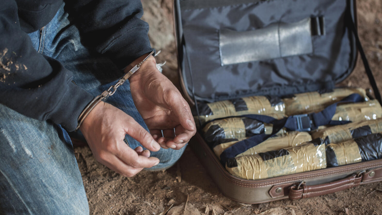 Drug traffickers were arrested along with their heroin. Police arrest drug trafficker with handcuffs. Law and police concept,26 June, International Day Against Drug Abuse and Illicit Trafficking