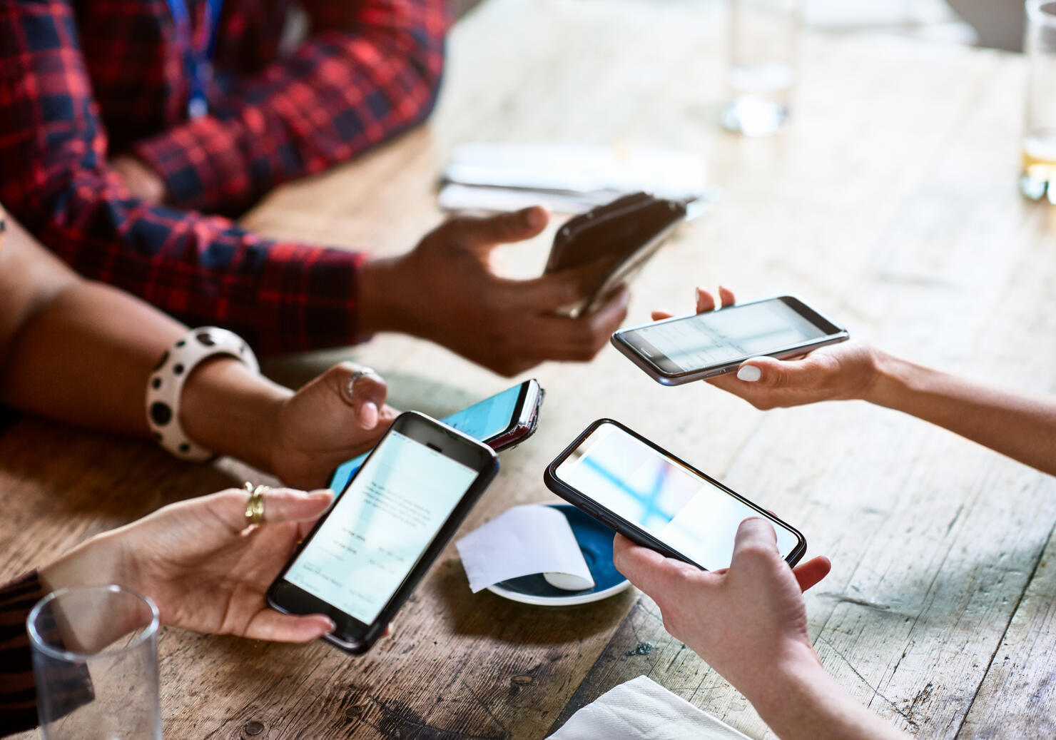 Friends splitting bill using contactless payment on smartphones