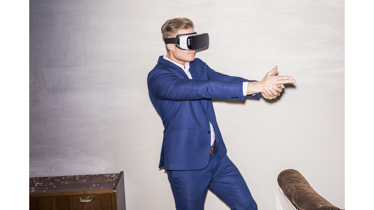 Young man wearing blue suit using Virtual Reality Glasses