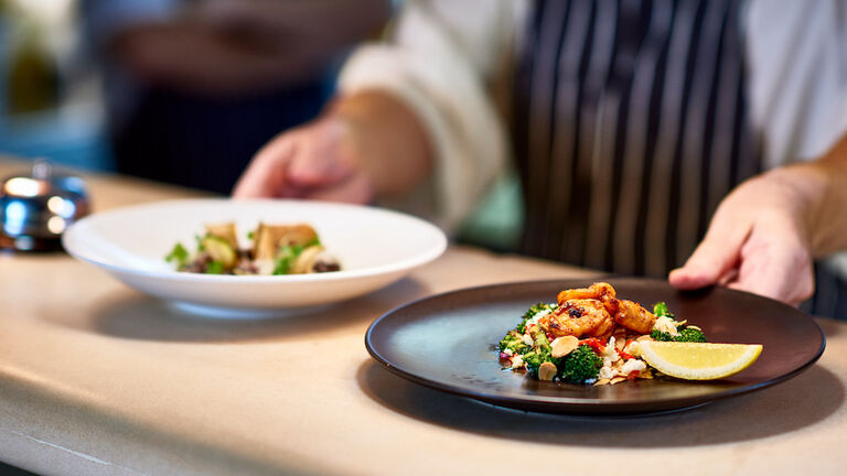 Chef placing dishes of prepared food on counter