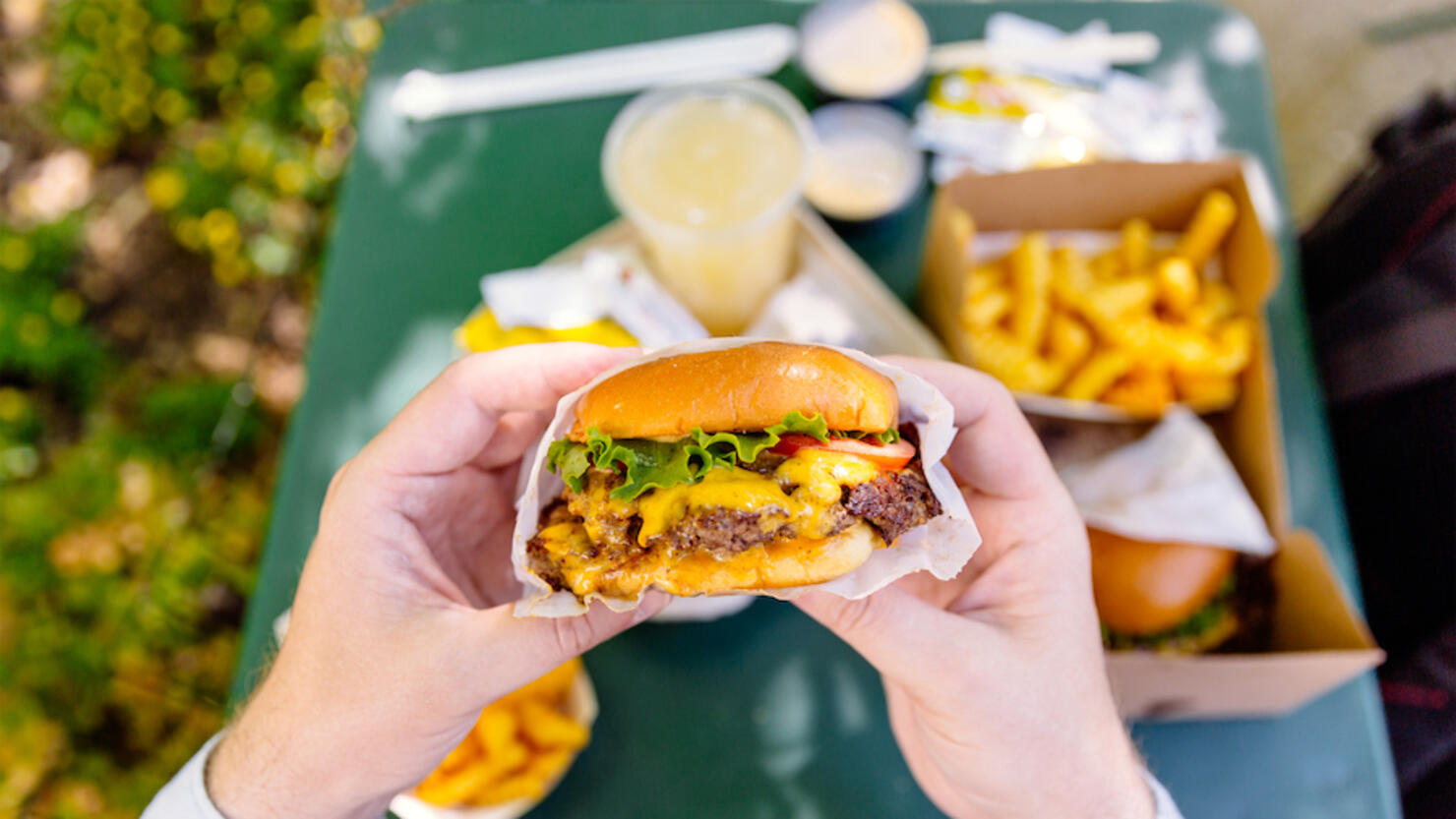 Man eating cheeseburger, personal perspective view