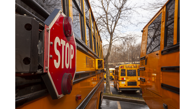 A close up image of yellow American school bus with selective focus on the stop sign on the side.