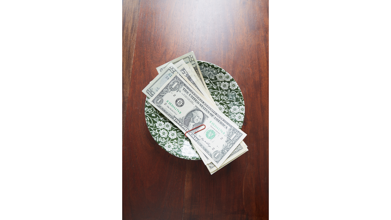 High angle view of dollar notes on plate