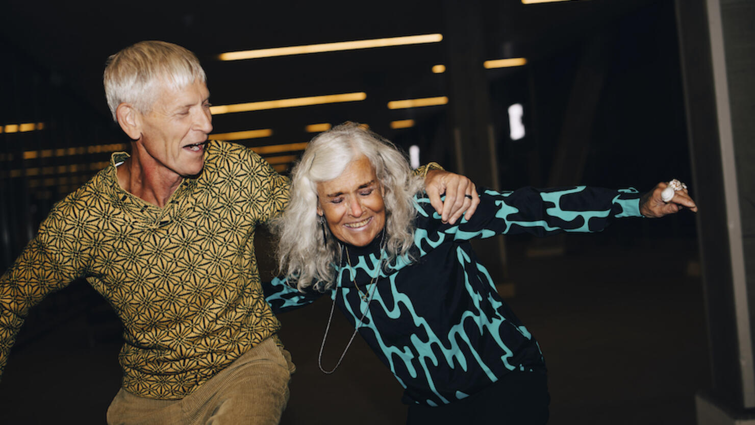 Senior man and woman dancing in parking garage