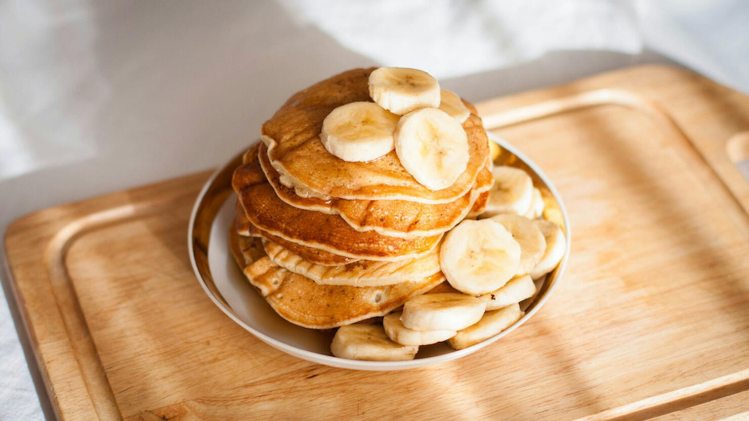 High Angle View Of Pancakes With Banana In Plate On Table
