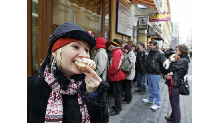 A girl eats a doughnut as other customer