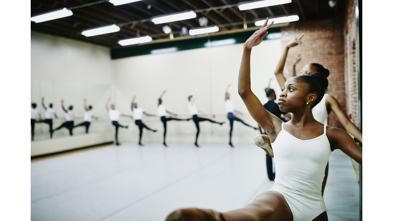 Young ballet dancers practicing at barre in studio