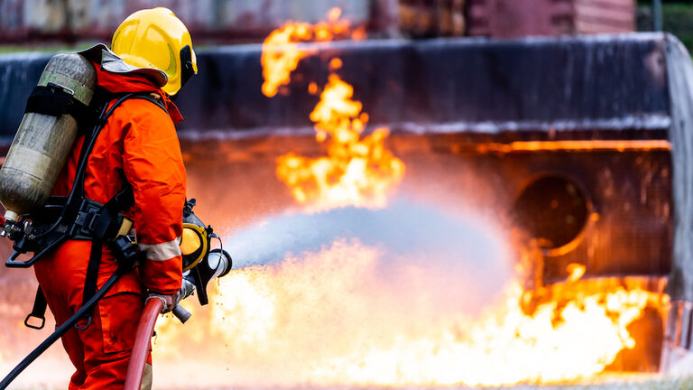 Firefighters spraying down fire flame from oil tanker truck accident