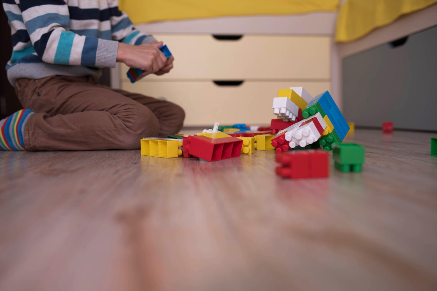 a little boy playing with colored cubes on the floor