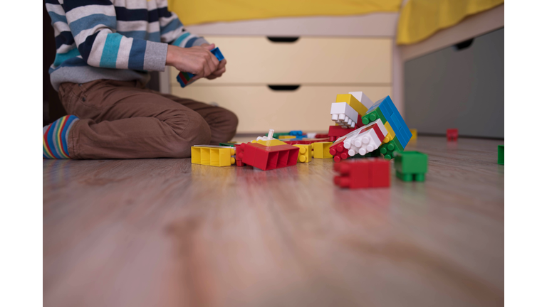 a little boy playing with colored cubes on the floor