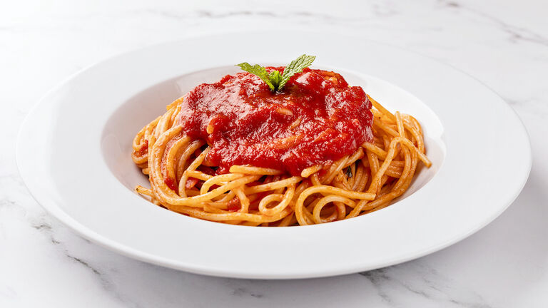 Spaghetti with tomato sauce on white background.