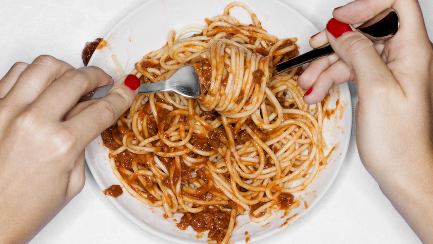 Female eating spaghetti, overhead view