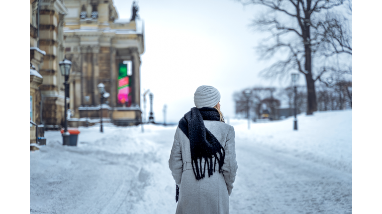 Woman walking on snowy street