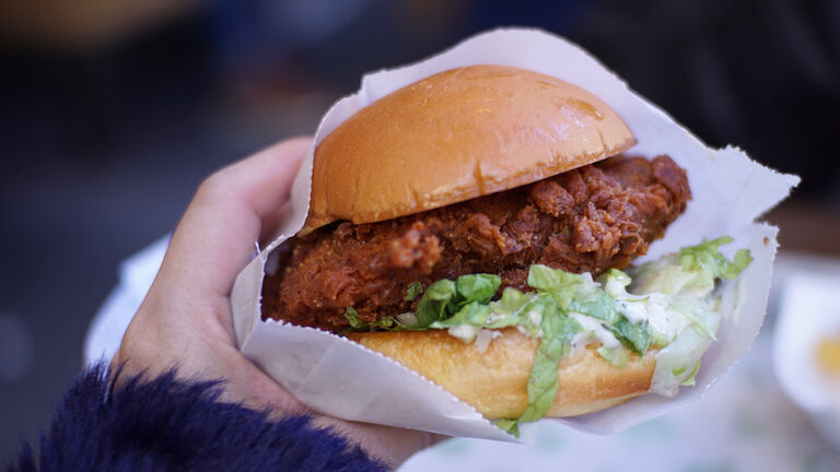 Close-Up Of Hand Holding Burger